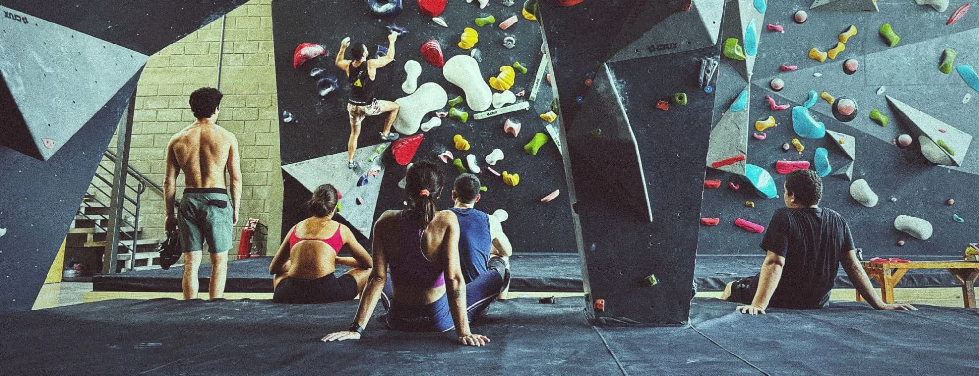 Pessoas escalando e descansando juntas no ginásio da Geometrik
